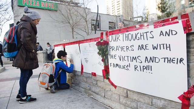 People sign a memorial in Toronto after a van mounted a sidewalk crashing into a number of pedestrians on Monday, April 23, 2018. THE CANADIAN PRESS/Nathan Denette