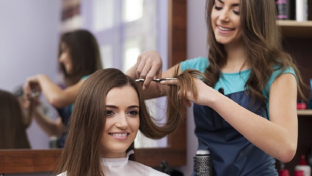 Beautiful woman has cutting hair at the hairdresser